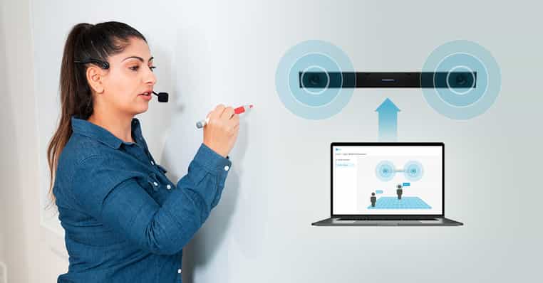 Instructor at whiteboard wearing a wireless headset microphone and using Adaptive Voice Amplification.